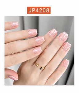 Detail of square nude pink press-on nails with white polka dots and glossy finish
