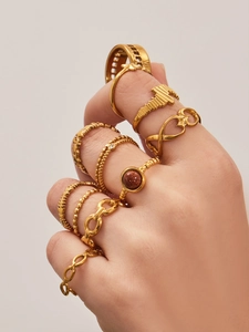 Macro shot of gold geometric ring set with star charms and brown sandstone inlay