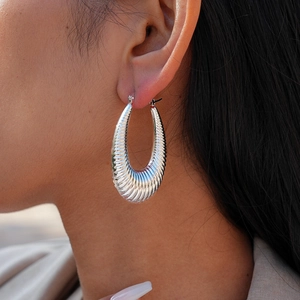 Silver geometric textured oval hoop earrings with retro ribbed croissant pattern design