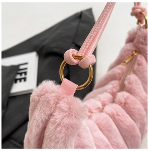 Dettaglio borsa a mano in peluche rosa con anello in metallo dorato e zip lucida