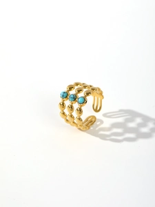 Detail of gold beaded band ring featuring three circular turquoise stones on white background