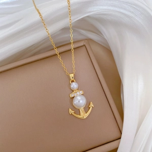 Elegante collana con ancora dorata, perle bianche e diamanti su seta bianca