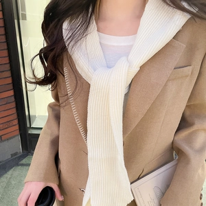 Close-up of camel wool blazer with white contrast stitching and a ribbed knit scarf