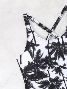 Detail view of tropical coconut tree print and cross strap design on tankini swimwear