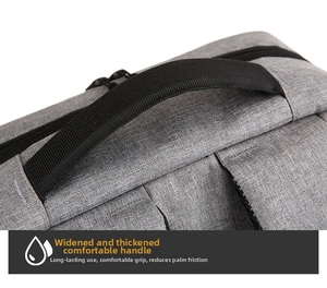 Close-up of the widened black nylon handle and gray textured fabric on the travel backpack