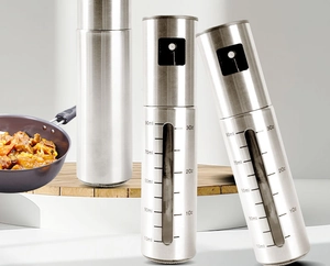 Detail of oil sprayer bottle with scale marks and stainless steel top in a kitchen setting