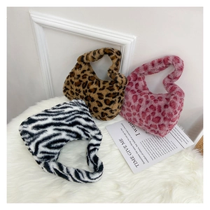 Three small plush tote bags in leopard, pink leopard and zebra prints on white rug