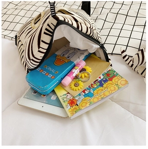 Macro view of zebra print plush kids backpack interior showing spacious storage for school