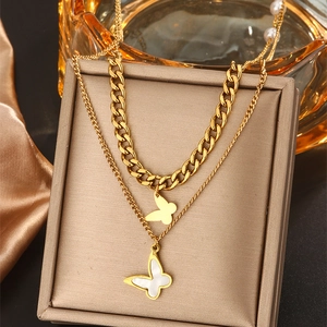 Macro shot of double-layer gold butterfly necklace displayed on a brown jewelry box