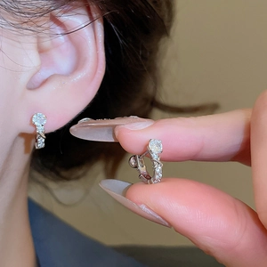 Detailed view of silver U-shaped hoop earrings with sparkling zircon gemstones