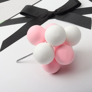 Detail shot of pink and white foam balloon clusters for birthday cake decoration