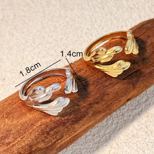 18k gold and silver leaf shaped open rings on wood surface with 1.4cm 1.8cm size markings