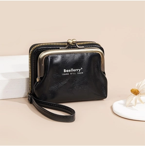 Detail of black leather coin purse with litchi texture and golden clasp hardware