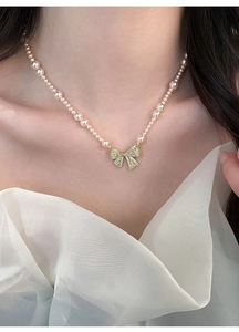 Detailweergave van zirkon strikhanger op een elegante Franse vintage parelketting