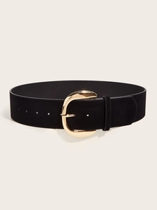 Detail of wide black suede waist belt featuring a large gold U-shaped metal buckle