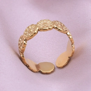 Detailed close-up of adjustable gold daisy ring featuring five embossed floral patterns