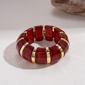Macro view of wide red glitter resin block bracelet with gold metallic links