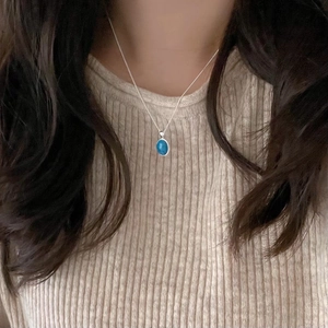 Minimalist 925 sterling silver necklace with oval turquoise pendant worn on a collarbone