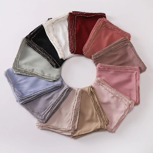 Flat lay of colorful chiffon scarves in a circular layout with elegant gold bead trimming