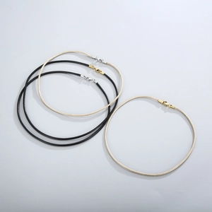 Detail of woven leather cord necklaces in black and beige with gold and silver metal clasps