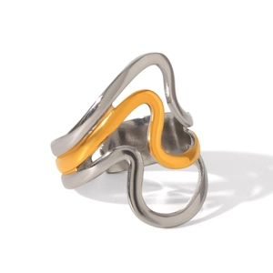 Detailed macro of irregular wavy two-tone stainless steel ring with gold and silver curves