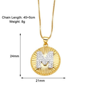 Detailed view of gold-plated letter M necklace with sunburst texture and zirconia stones