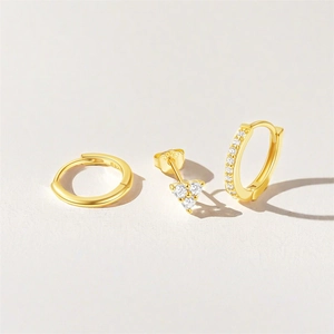 Macro shot of S925 sterling silver gold trio set featuring hoop and heart stud earrings