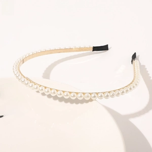 Close-up of minimalist gold metal headband with uniform white pearls and black end tips