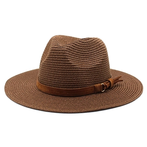 Detail of dark brown fedora straw hat with suede band and metallic buckle accent
