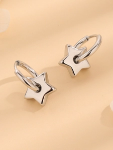 Detailed close-up of polished silver star-shaped dangle earrings with metallic luster