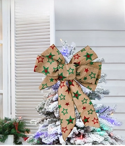 Linen Christmas tree bow featuring red and green star prints on a snowy branch