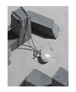 Detailed macro view of Baroque freshwater pearl necklace with silver OT clasp on concrete