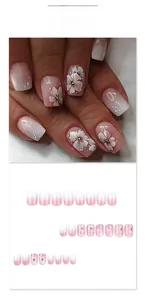 Pink and white gradient press-on nails with white flower patterns and pearl accents