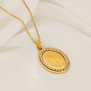 Gold oval Virgin Mary pendant necklace with zircon stones on white silk background