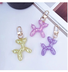 Detailed view of yellow, pink, and purple balloon dog keychains with metallic pearl finish