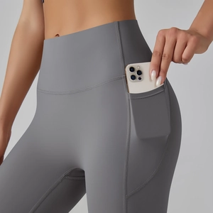 Detail view of high waist yoga leggings with functional side pockets and matte gray fabric