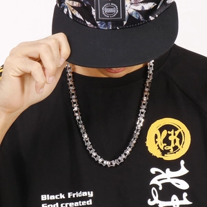 Macro shot of a silver geometric chain necklace worn by a model in streetwear style