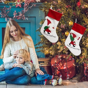 Red and white Christmas stockings with 3D Santa gnome decorations by a cozy fireplace