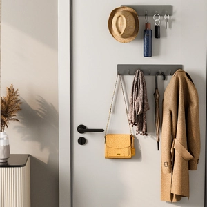 Gray wall-mounted punch-free row hooks for hats and coats in a cozy home entrance setting