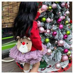 Sac à dos crochet fait main pour enfant motif cerf porté près d'un sapin de Noël
