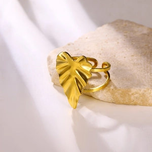 Detailed macro of golden monstera leaf ring with matte finish and adjustable double band