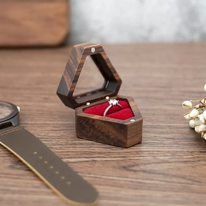 Macro shot of hexagonal wooden jewelry box featuring red velvet lining for single ring