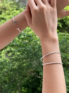 Detailed view of silver stackable jewelry set including T-bar cuff and beaded bracelet