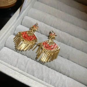 Detail of fan-shaped tassel earrings with red enamel and rhinestones in a gift box