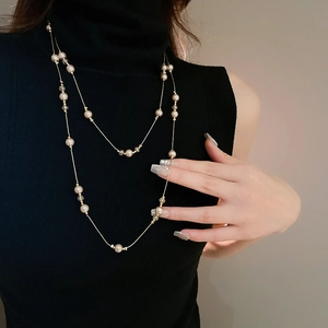 Détail d'un collier double couche avec perles de champagne et cristaux dorés