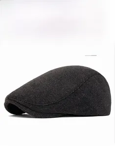 Close-up of dark gray newsboy cap featuring classic herringbone wool texture details