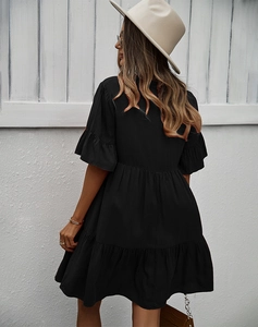 Vue de dos d'une robe noire à volants avec un chapeau de soleil blanc élégant