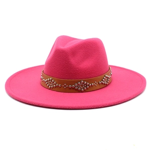 Dettaglio cappello in lana rosa rosso con fascia in pelle marrone e borchie d'argento