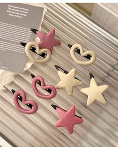 Détail de barrettes à cheveux rose en forme de cœur et d'étoile sur verre texturé