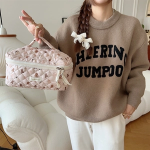 Detail of pink quilted makeup bag with cute bear print and sturdy top handle